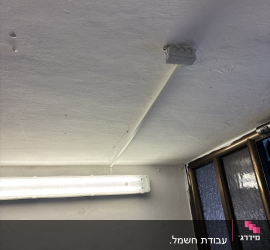 תאורת פלורסנט מותקנת על תקרה לבנה